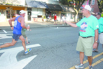 Terry and Scott Thomas cheer on runners as they make it to the finish line during the 7th Inning Stretch National Guard 5K.