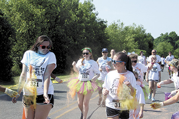 Participants in the Fun Run get doused with an array of colors by spectators as they neared the finish line.