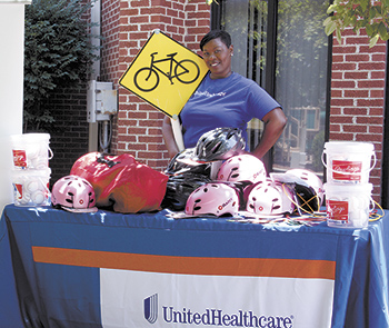Mahogany Graham, Community Relations Specialist of United Healthcare proudly displays the additional gifts in addition to the 50 bikes which were given to the Boys & Girls Club of Cleveland County. 