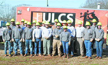 Academy students gather around the utility trailer donated by Utility Lines Construction Services.