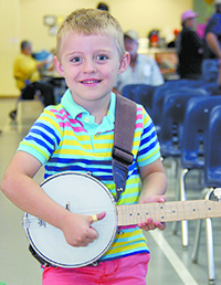 Four-year-old Colton Robbins, poses for a photo with his banjo at the 2nd Annual Dan Padgett Jamboree. Colton just started taking lessons from Dan.