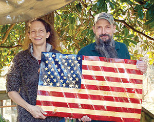 Overmountain Woodworks owners and operators Chuck and Brandy Greene with one of the American flags they recently made.
