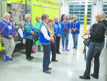 Sara Tongel (right), is one of the two female firefighters on the firehouse staff of 36, gives an equipment demonstration to the ladies of Shelby\'s American Legion Auxiliary Unit 82.