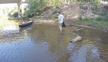 Dennis used his canoe to ferry tires and garbage around as they made their way down the river.