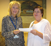 Left to right: Myra McGinnis, Hospice CEO receives check from Karen Earl, Walmart Transportation.