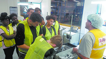 Teens look on as a worker explains a surgery kit during a tour of Owens & Minor in Kings Mountain.