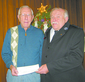 The $3,089 check being given by Reid Sipe of Kings Mountain to Sgt. Les Ashby of The Salvation Army represents a year\'s efforts at repairing clocks. Sipe\'s annual donation comes in memory of his wife and grandson.  Photo courtesy Cassie Herndon Tarpley