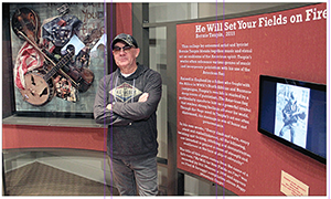 Bernie Taupin poses by his exhibit "He Will Set Your Fields on Fire" at the Earl Scruggs Center.