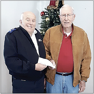 Reid Sipe "The Clock Man" gave check for $1,987 to Sgt. Les Ashby, Corps Administrator for The Salvation Army.