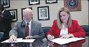 GWU Provost and Executive Vice President Dr. Ben Leslie, left, and Melissa LaBruzzy, Walmart Distribution Center human resource manager, sign their portion of the agreement.