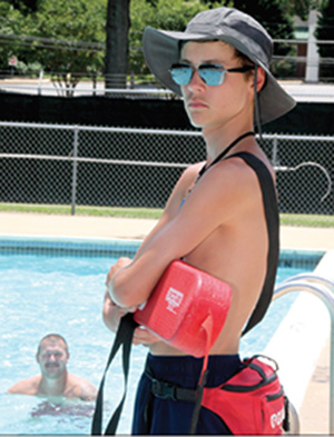 Lifeguard Jacob Kennon keeps an eye on swimmers at the Shelby Aquatic Center .
