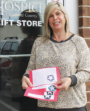 Krista Haynes, Hospice Cleveland County Patient/Family Volunteer Coordinator with examples of the letters written to patients who are veterans as part of their "We Honor Veterans Program". 