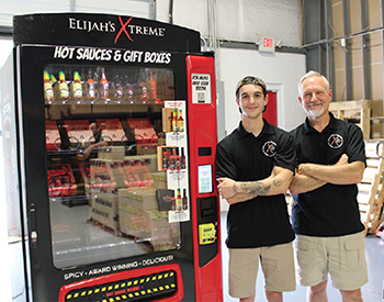 Bret Morey and son, Elijah, with their new Elijah\'s X-Treme hot sauce vending machine.