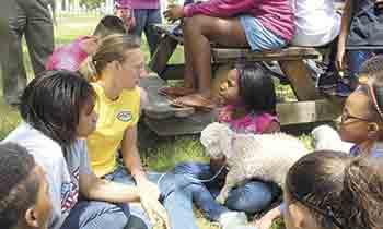 Children circle around Allison Stumbo as she introduces the two new angora goats to children at the Boys & Girls Club.  Some to the children will learn more about the goats when they spend a week at SonRidgeFarm this summer.