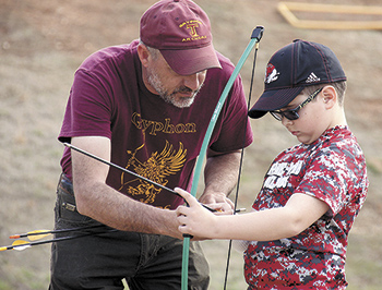Jack Causby Archery Team Coach at TJCA gives some archery tips to Finn Parker.