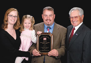 Pictured, left to right: Mandi and Brian Parker with their daughter; and Elton Braswell, NC Farm Bureau Vice President.