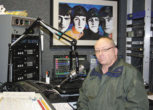 Jeff Powell is positioned in the main studio with the â€œshow and tellâ€ equipment that stores over 130,000 musical choices.