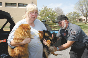 Volunteer Joe Hurdt gives Susan McGloneâ€™s dogs,â€Tobyâ€ and â€œBabyâ€, their free shots.