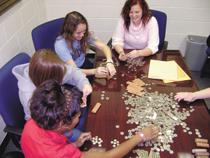 Mariah Webber, Beth Wilson, Brittany Horn and Taylor Wright gather some of the $2500 worth of coins.