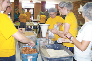 Students prepare food packages for shipping.