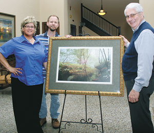 Tracy Stilwell of Victorian Rose Studio;  Phillip Philbeck, Artist and Jack Weller of the Cleveland County Boys & Girls Club display this yearâ€™s donated painting that will be auctioned to provide funds for the club.