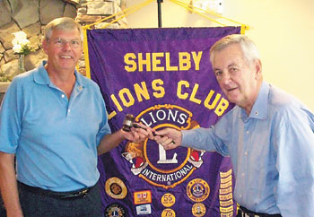Outgoing  Lion  President  Jimmy  Tucker,  right,  hands  the  gavel  to  incoming  President  Dave  Titus.