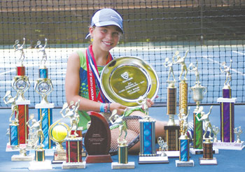 Tennis champ Natalie Lutz is pictured among her many championship trophies won this year and is holding her championship plate for the USTA Southern Title.