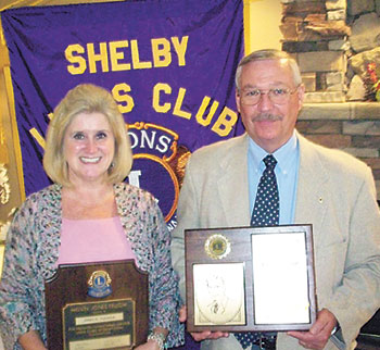 Jan  Tucker  (left)  was  named  a  Melvin  Jones  Fellow,  and  Jim  Holland,  (right)  was  named  a  Jack  Stickley  fellow  by  the  Shelby  Lions  Club. Not  pictured:  Lion  Dave  Titus,  who  was  named  Lion  of  the  Year.