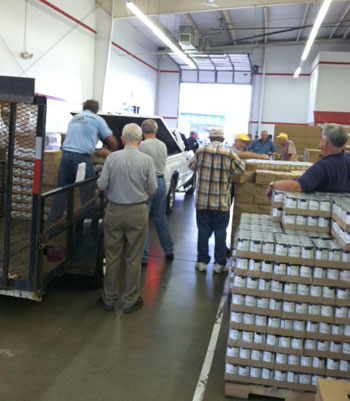 Volunteers unload one of several trucks carrying food that will feed 2800 families for 6 weeks.  Food is distributed once a quarter through various agencies.