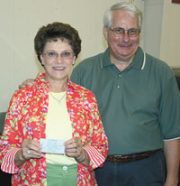 Holding her lucky #138 winning ticket, Joann Lutz stands next to her new Ford Ranger with Club President, Jack Weller. 