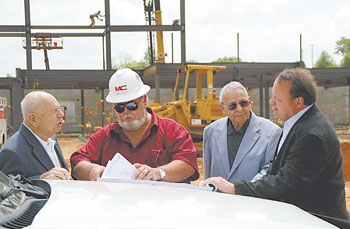 Standing at the construction site of the LeGrand Center, reviewing plans and discussing the projectâ€™s status, are (l to r) Gene LeGrand, Charlie Dubold of Matthews Construction, Bill LeGrand and Stuart LeGrand.