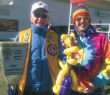 Becki  Julian  ( right )   presents  a  balloon  lion  to  J.D.  Baldree  of  the  Shelby  Lions  Club.