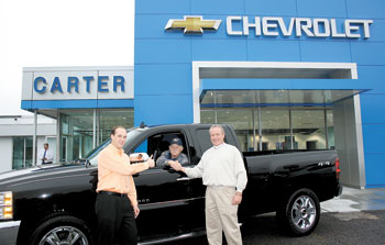 Paul Carter of Carter Chevrolet gives a thumbs up as Carter Sales Consultant, Wayne Gregory congratulates NC Lottery winner, Dan Royal on the purchase of his new Chevrolet Silverado.