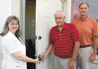 Cathy Robinson, Executive Director of the Abuse Prevention Council of Cleveland County, hands the keys to â€œThe Beaconâ€ menâ€™s shelter to the new Operations Manager, David Blanton of the Interfaith Alliance who will now run the facility. Jess Powell, 
