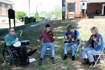 Performing for visitors at the KM Historical Museum Spring Fling is the  "Log Cabin String Band". (L to R) Tommy Forney, Brad Herndon, Charles Watts and Lynn Eskridge set up camp outside in the shade at the entrance of the historic Robert Barber house.