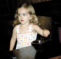 Anna drops some change in the mission box during the Church service. 