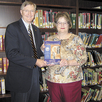 Ted Alexander, Western Regional Director for Preservation North Carolina presents a copy of â€œA Lasting Gift Of Heritageâ€ to Carol Wilson, Director of the Cleveland County Memorial Library.