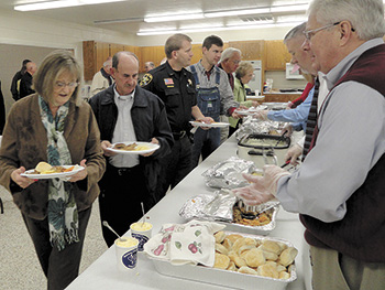 Folks line up at the recent Farm-City 'Local Foods' Breakfast, sponsored by Kiwanis Club of Shelby. From left being served, Sara and Loyd Lewis, Thomas Lewis and Donald Eslick. Right forefront serving are Jack Weller and David Costner.