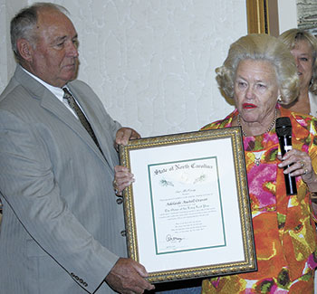 As Adelaide Craver took the time to thank everyone, Cleveland County Commissioner Johnny Hutchins held her prestigious award.