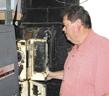 Owner, Rick Stinnett changes over film on the current projector system at Bessemer City - Kings Mountain Drive-in.  