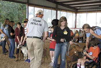 Students from Burns High School assist the participants  of North Shelby with their goats.