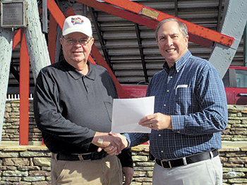 Bobby Jenks (left) and Lloyd Williams sign agreement for Hog Happninâ€™ barbecue event to return to Cleveland County Fairgrounds.