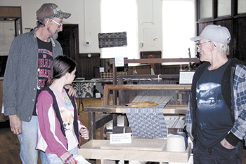 Roger Suttles (on left) with his granddaughter, Haylee and neighbor (on right) Norman Bradley were among the first to visit. Mr. Suttles, who worked in the mills, said the display brought back â€œa lot of memoriesâ€.