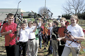 Students anxiously await their turn to shoot their bow during their first lesson. 