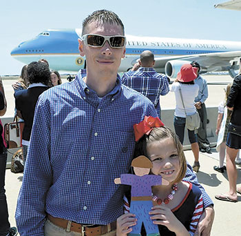 Sgt. Jeff Bradley gives his daughter Kaitlyn a hug in front of Air Force One.