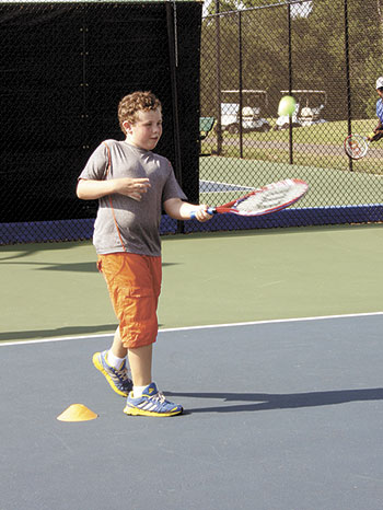 9-year-old Walton gets tennis lessons on the newly refurbished tennis courts. 