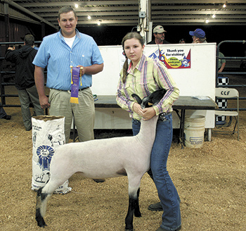 Regan Mitchem takes home the Grand Champion prize for her age group at Mondayâ€™s contest. Judge Tom Devine is at left. 
