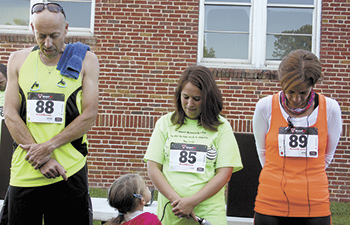 Greg Goodman, Alicia Garren and Shelia Goodman pray before the start of the 5K race.