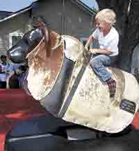 Henry Ladner has fun riding a mechanical bull.