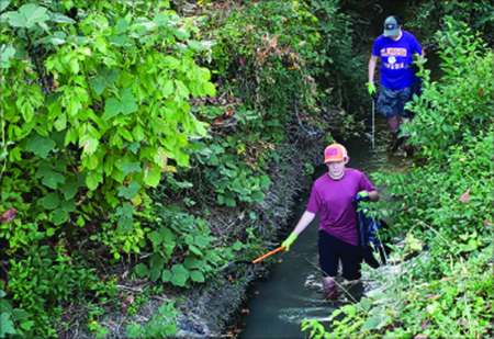 In front is Ethan Bowen followed by Lucas Howell volunteering in the clean up.